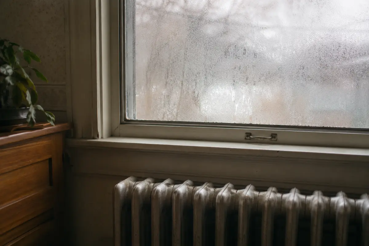 Condensation fogging a cold window in a New England home in winter